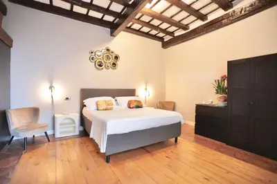 a bedroom with a large bed and a chair at Biscione Dream Campo de'Fiori in Rome