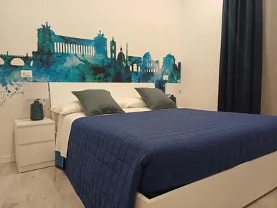 a bedroom with a blue bed with a painting on the wall at Lux Urbis Pio VIII in Rome