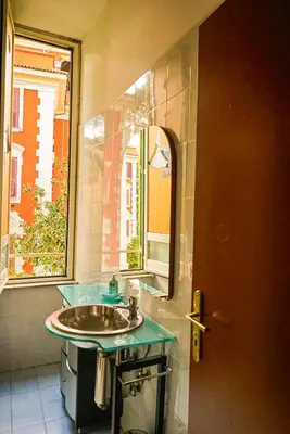 a bathroom with a sink and a mirror and a window at PP Stanza Privata in Appartamento Pigneto in Rome