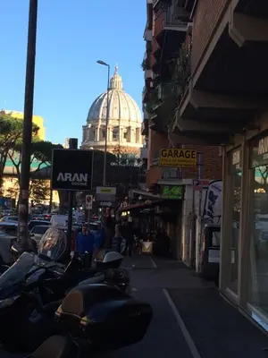 a row of motorcycles parked on a city street with a building at Argilla Apartment in Rome
