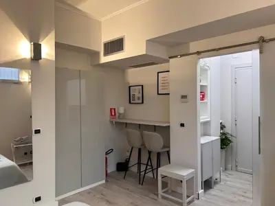 a room with white walls and a counter and chairs at Charme Holidays San Saba in Rome