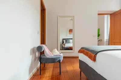 a bedroom with a bed and a chair and a mirror at iFlat Spanish Steps Chic & Warming Hideaway in Rome