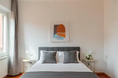 a bedroom with a large white bed with gray pillows at iFlat Spanish Steps Chic & Warming Hideaway in Rome