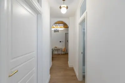 a hallway with white walls and wood floors at iFlat Monti Charming & Cozy Apt by the Colosseum in Rome