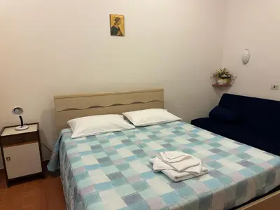 a bedroom with a bed with a blue and white checkered blanket at Casa per Ferie Eden Cusmano in Rome