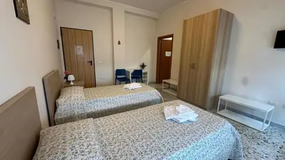 a hotel room with two beds and a desk at Casa per Ferie Eden Cusmano in Rome