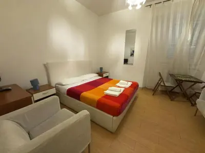 a bedroom with a bed with a colorful blanket and a couch at Great studio near Coliseum in Rome
