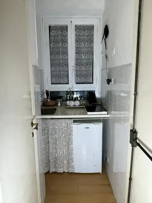 a small kitchen with white cabinets and a sink at Great studio near Coliseum in Rome