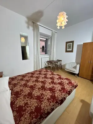 a bedroom with a large bed and a chandelier at Great studio near Coliseum in Rome