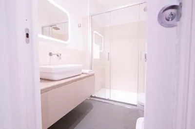 a white bathroom with a sink and a shower at Le Dimore del Duca in Rome