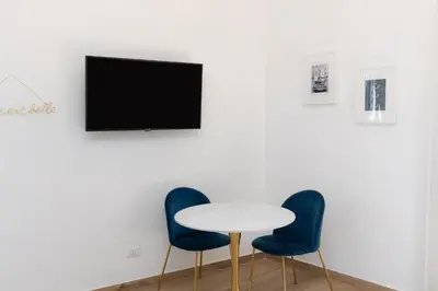 a white table with two chairs and a tv on a wall at Vatican Walls Apartment in Rome