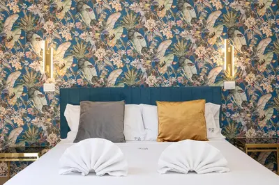 a bedroom with a bed with a floral wallpaper at Vatican Walls Apartment in Rome