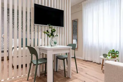 a living room with a table and a tv on a wall at Casa Bressan in Rome
