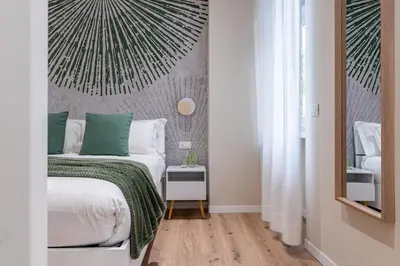 a bedroom with a bed with a green blanket at Casa Bressan in Rome