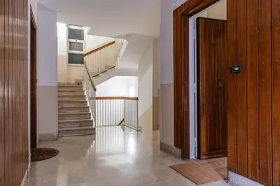 a hallway with stairs and a wooden door at Casa Bressan in Rome