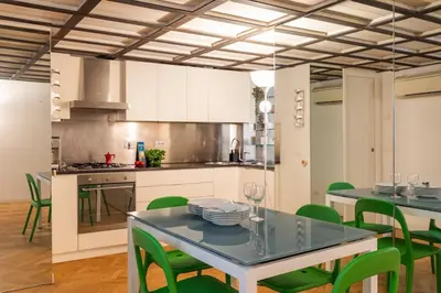 a kitchen with a dining table and green chairs at Navona award Collection in Rome