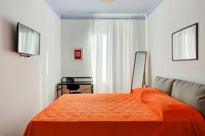a bedroom with an orange bed and a couch at Casa Chiro 79 in Rome