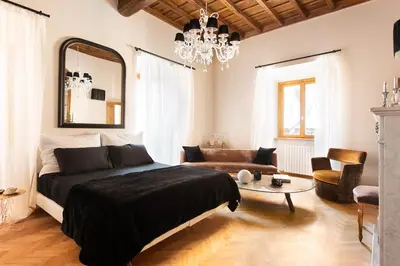 a bedroom with a large bed and a chandelier at Idyllia - Luxury home with terrace in Rome