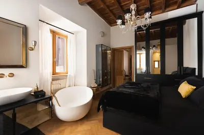 a bathroom with a tub and a bed and a sink at Idyllia - Luxury home with terrace in Rome