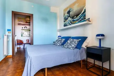 a bedroom with a bed and a painting on the wall at Appartamento con balcone a San Giovanni, piano alto con vista su Roma in Rome