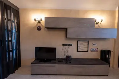 a living room with a television and a staircase at Casa Mercanti in Rome