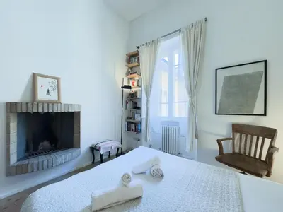 a white bedroom with a bed and a fireplace at The Loft Boutique Apartment Vatican Museum in Rome