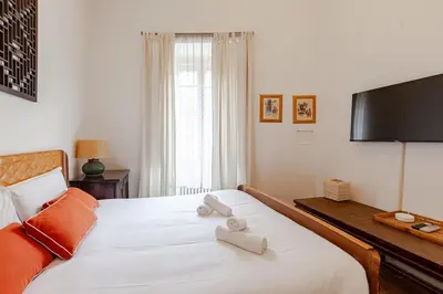 a bedroom with a large white bed with a flat screen tv at The Loft Boutique Apartment Vatican Museum in Rome