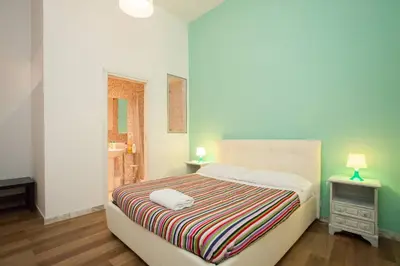 a bedroom with a bed with a striped blanket at Large Apartment near Coliseum in Rome