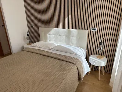 a bedroom with a large bed with a striped wall at Green Hotel in Rome