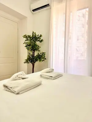a white bed with two towels on top of it at Lolus House in Rome