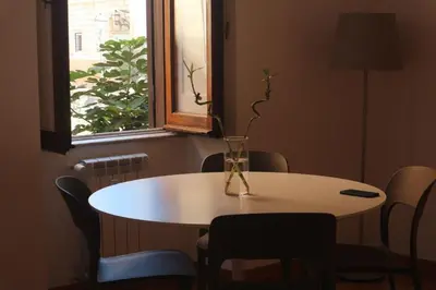 a table and chairs with a vase on top of it at Residenza Coronari in Rome