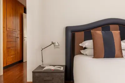 a bedroom with a bed with a lamp and a book at Casa Sacchi by Hili in Rome