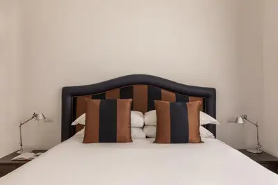 a bed with a black and brown headboard and pillows at Casa Sacchi by Hili in Rome