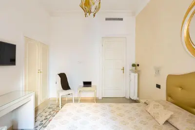 a bedroom with a bed and a table and a chair at Relais Calamatta in Rome
