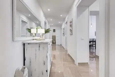 a hallway with white walls and a table with a lamp at FaMa - Mecenate 3BR & 2BA in Rome