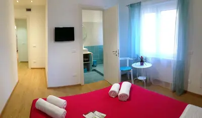 a bedroom with a red bed with a red blanket at Holiday Home Roma in Rome