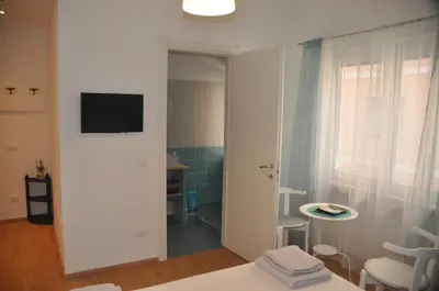 a white room with a window and a table and chairs at Holiday Home Roma in Rome