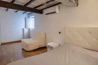 a bedroom with a white bed and a chair at Navona Square in Rome