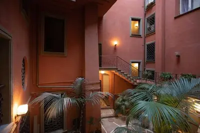 a building with stairs and palm trees in a courtyard at Casa Kevisco in Rome