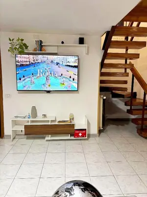 a living room with a large tv on the wall at Casa Kevisco in Rome
