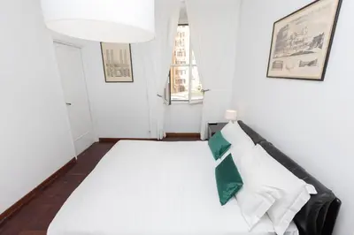 a bedroom with a white bed with a green pillow at Vatican Museum Family Apartment in Rome