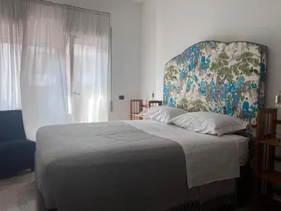 a bedroom with a large bed with a painting on the wall at Appartamento Eataly in Rome