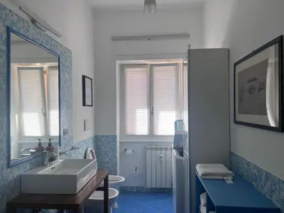 a blue and white bathroom with a sink and a mirror at Appartamento Eataly in Rome