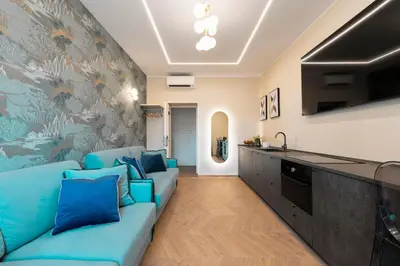 a living room with a blue couch and a kitchen at Lussuosa casa zona esquilino in Rome