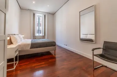 a bedroom with a bed and a mirror and a chair at Casa Lavinia - Basilica Santa Maria Maggiore in Rome