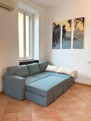 a blue couch in a room with two windows at Domus Mantellate, Trastevere in Rome