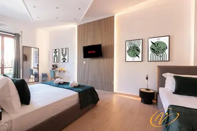 a bedroom with two beds and a television in it at Nuccia Luxury Apartment and Suites - Terrace, bright glass lounge, 200mt to Metro-5min to Vatican, A-C in Rome
