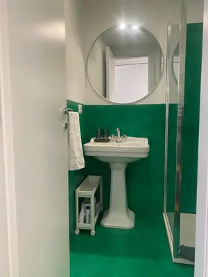 a green bathroom with a sink and a mirror at Navona Sweet Home in Rome