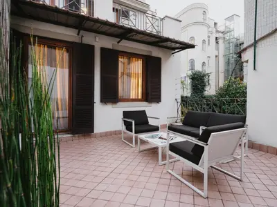 a patio with two chairs and a table at Unica Suites Rome in Rome