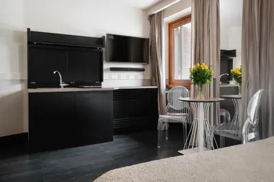 a kitchen with a sink and a tv and a table at Unica Suites Rome in Rome
